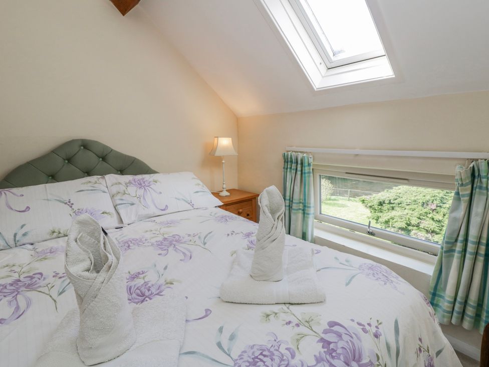 A bedroom with a bed and window at Gardener's Cottage Llanwrthwl near Rhayader