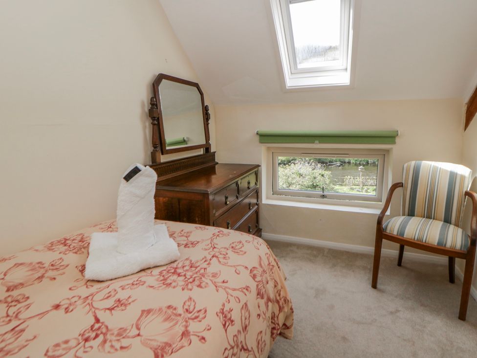 A bedroom with a bed and dresser at Gardener's Cottage Llanwrthwl near Rhayader