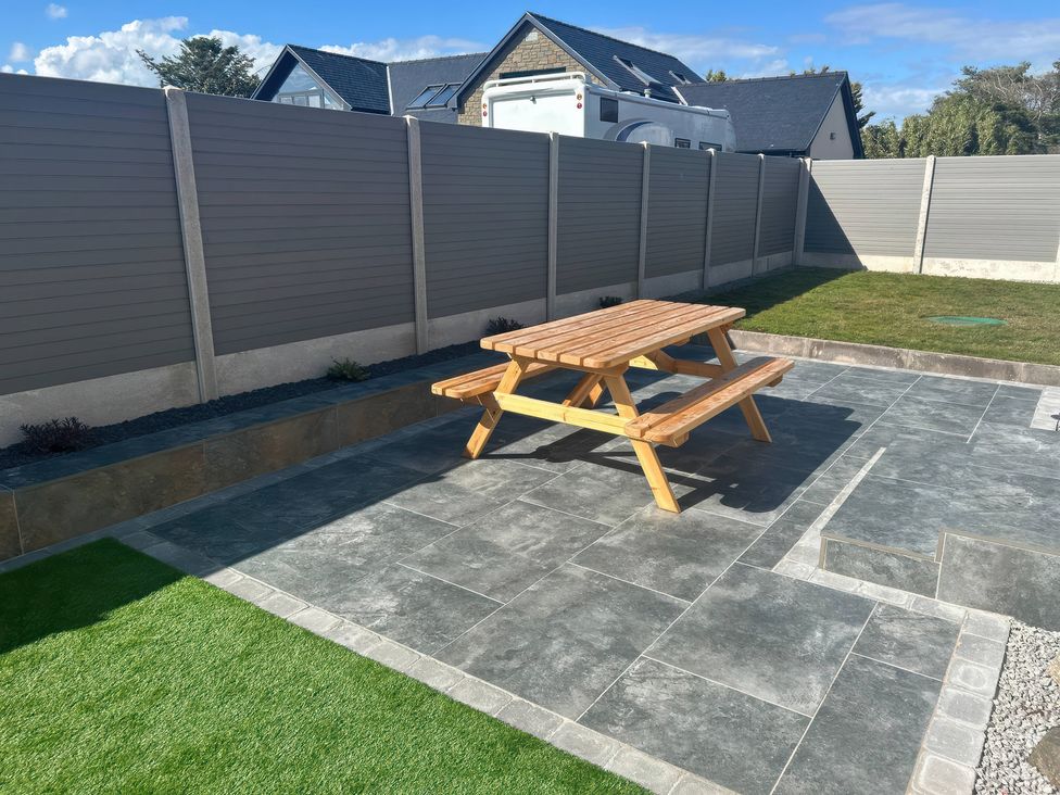 A garden with a picnic table and paving stones at The Bothy in Southerness