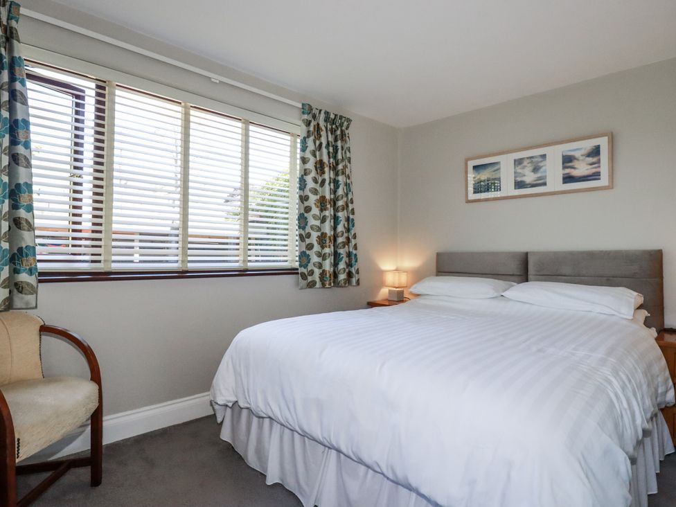 A bedroom with a double bed and a chair at Jenny Wren in Tywardreath near Fowey