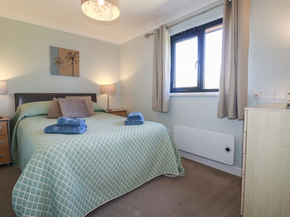 A bedroom with a bed and window at The Station Flat St Newlyn East near Newquay