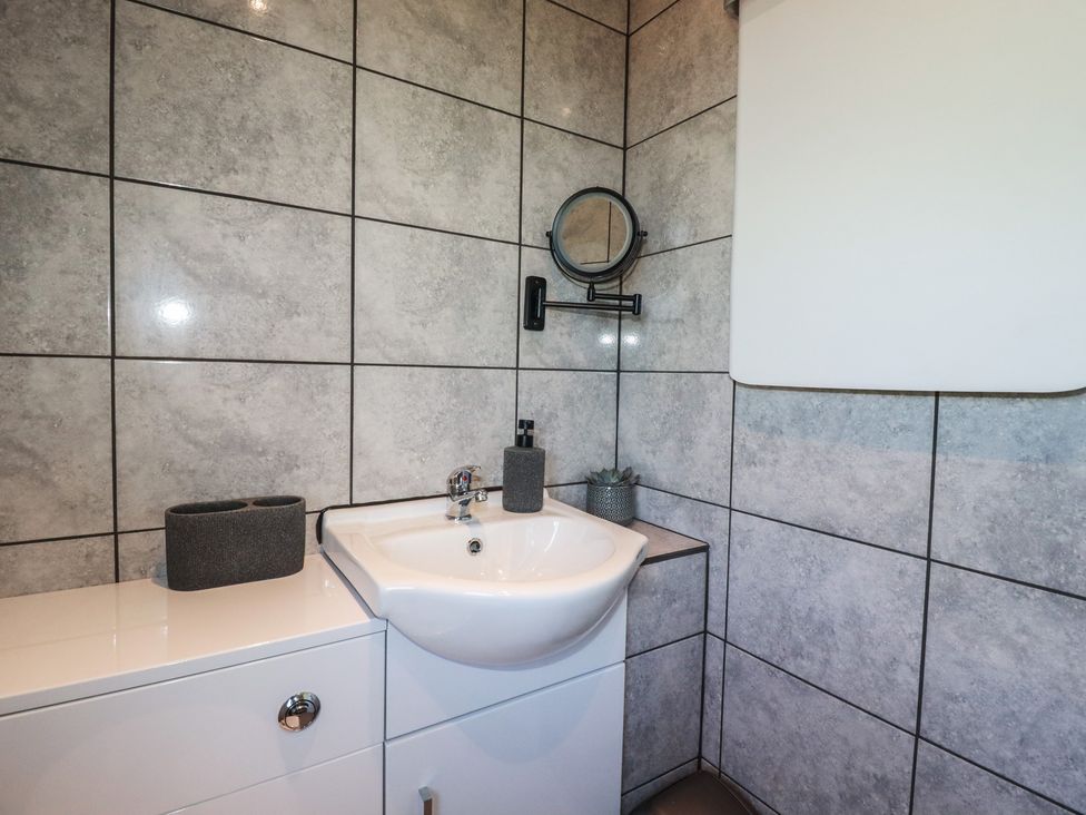 A bathroom with a sink and mirror at The Station Flat in St Newlyn East near Newquay