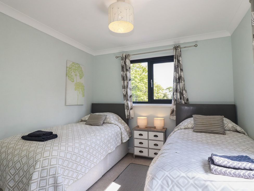 A bedroom with two single beds and a bedside table at The Station Flat St Newlyn East near Newquay