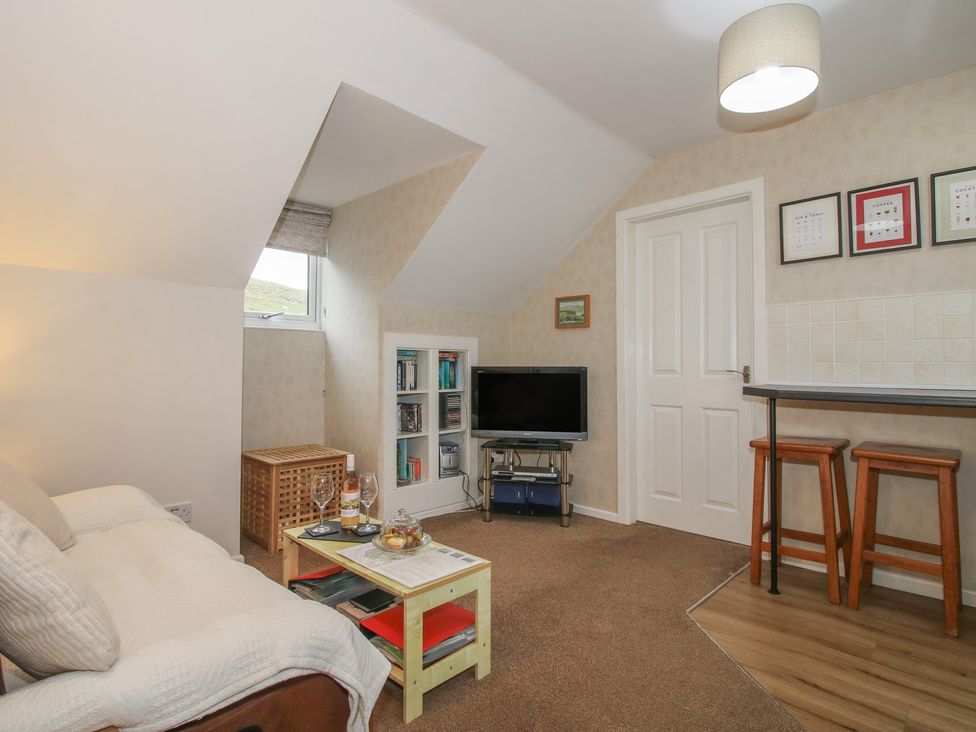 A living room with a television and bookshelf at Southview in Clee Hill near Ludlow