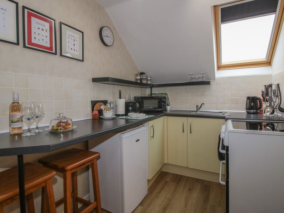A kitchen with bar stools and a microwave at Southview in Clee Hill near Ludlow