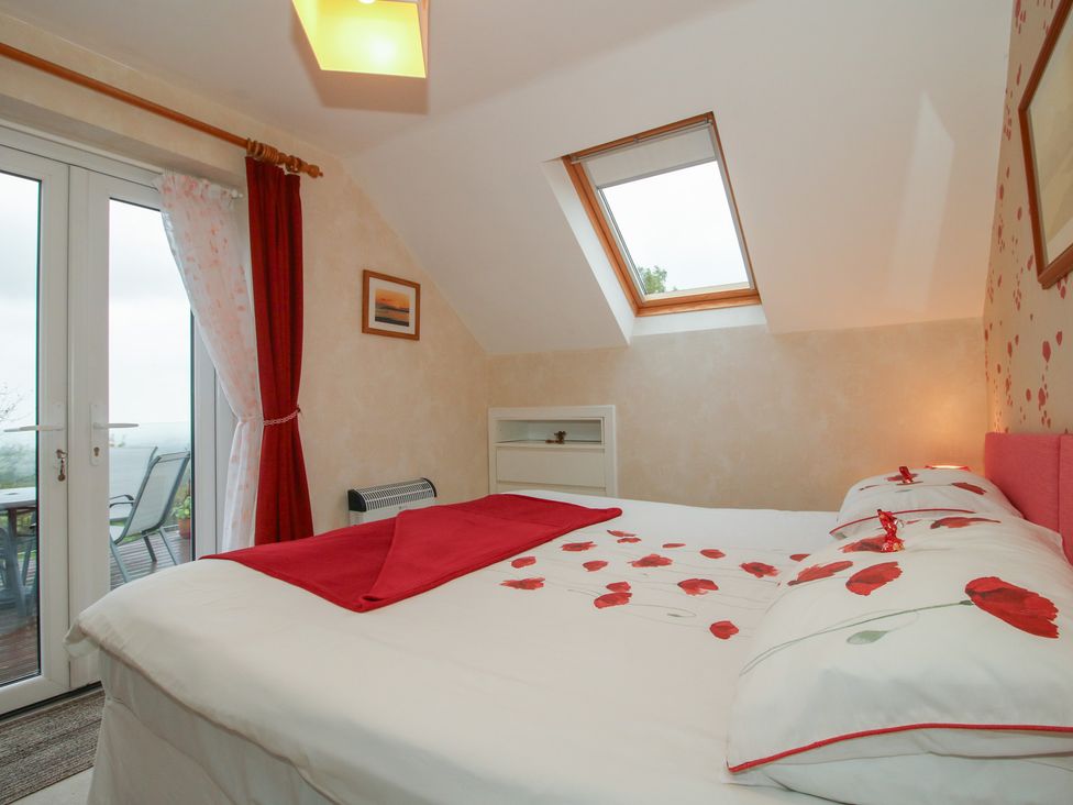 A bedroom with a large bed and windows at Southview in Clee Hill near Ludlow