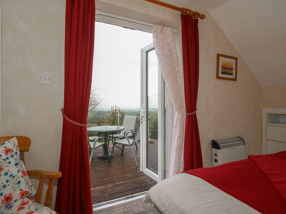 A bedroom with a door leading to a balcony at Southview in Clee Hill near Ludlow
