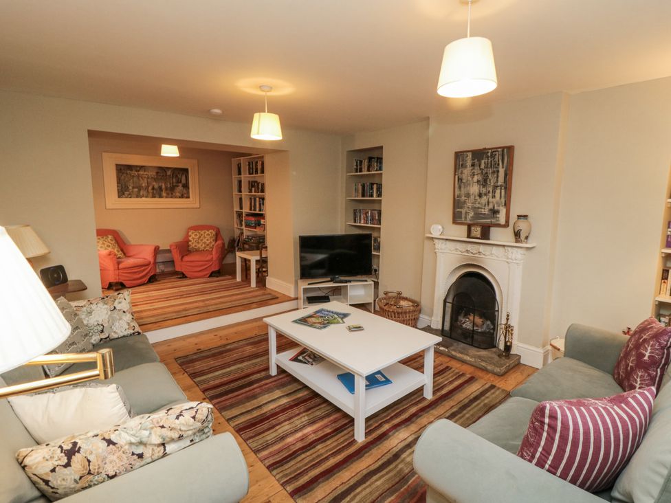 A living room with a coffee table and bookshelf at Brookleigh in Hutton-le-Hole