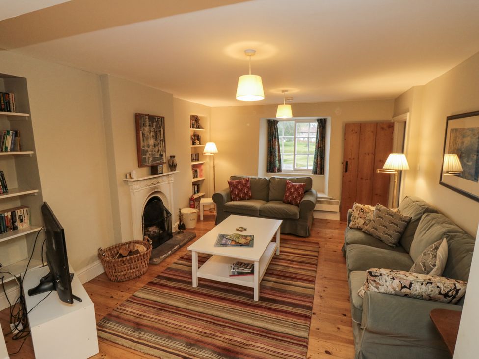 A living room with sofa and bookshelf at Brookleigh in Hutton-le-Hole