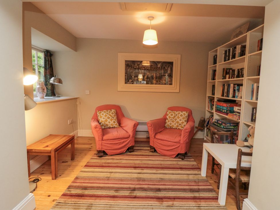 A snug with two armchairs and a bookshelf at Brookleigh in Hutton-le-Hole