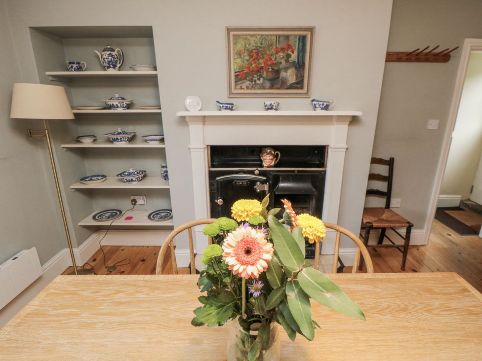 A dining room with a table and flowers at Brookleigh in Hutton-le-Hole