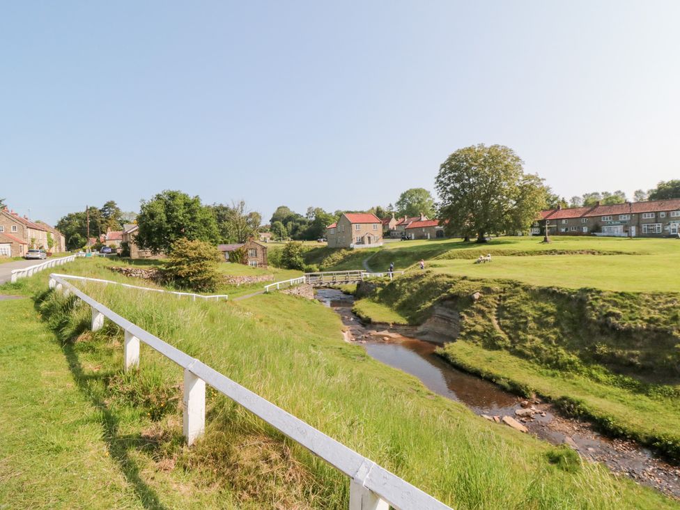 A view of houses and a stream in a rural area at Brookleigh Hutton-le-Hole