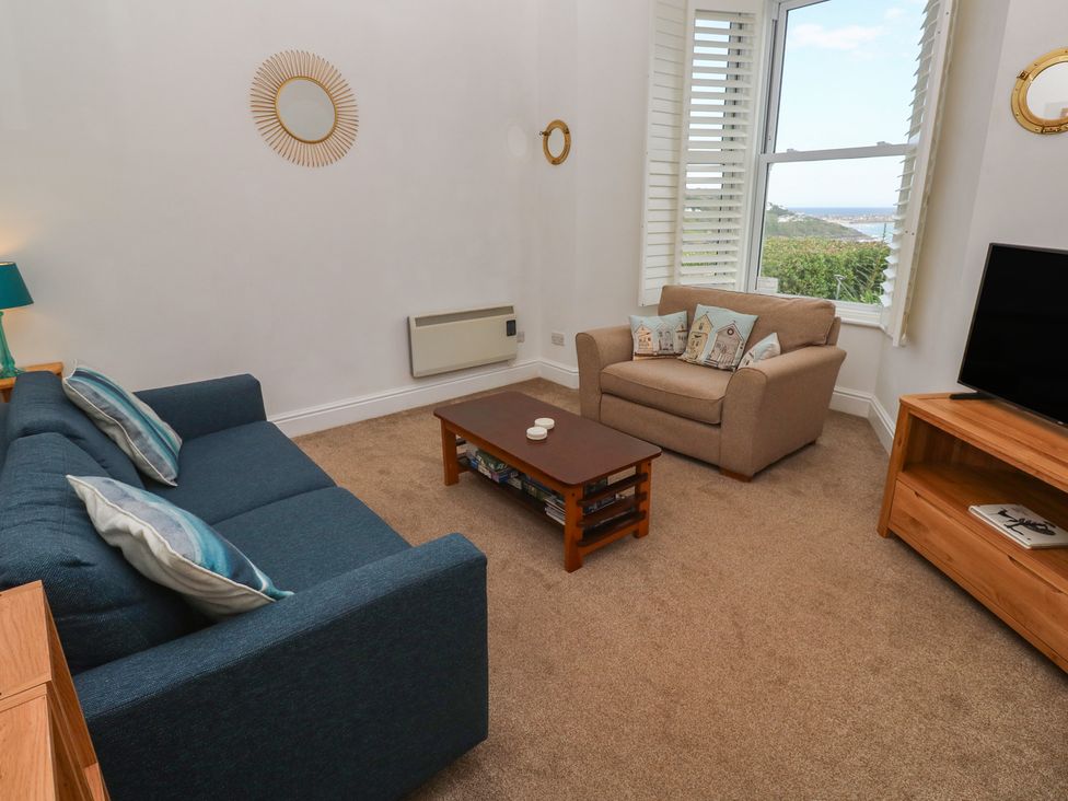 A living room with a sofa and armchair at Apartment 1 Llewellan in St Ives
