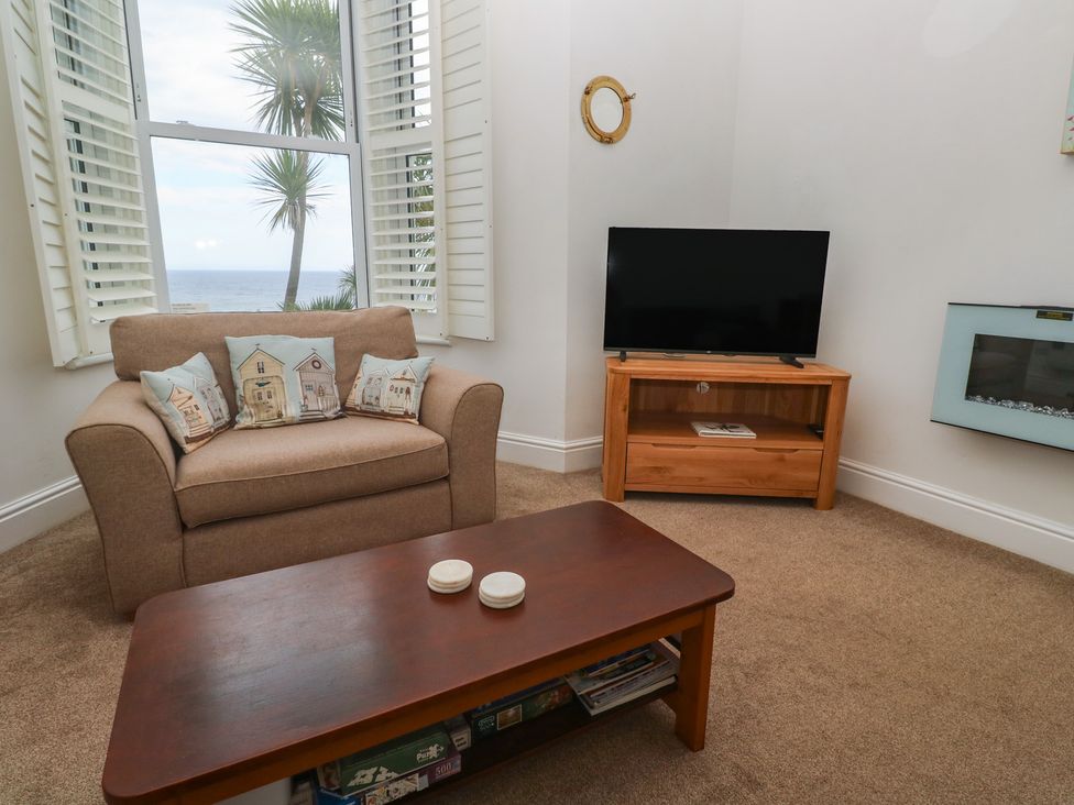 A living room with a sofa and television at Apartment 1 Llewellan in St Ives