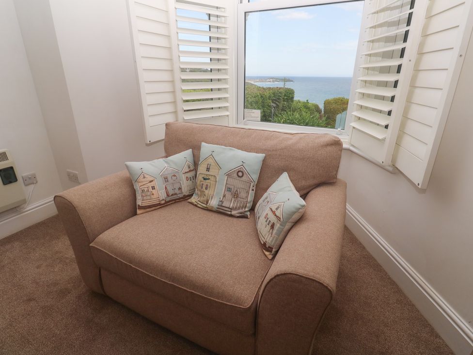 A living room with an armchair and cushions at Apartment 1 Llewellan in St Ives