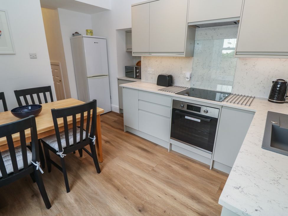 A kitchen with table and chairs at Apartment 1 Llewellan in St Ives