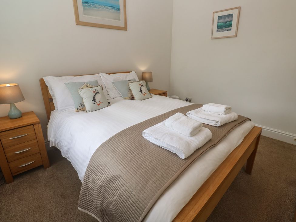 A bedroom with a bed and bedside tables at Apartment 1 Llewellan St Ives