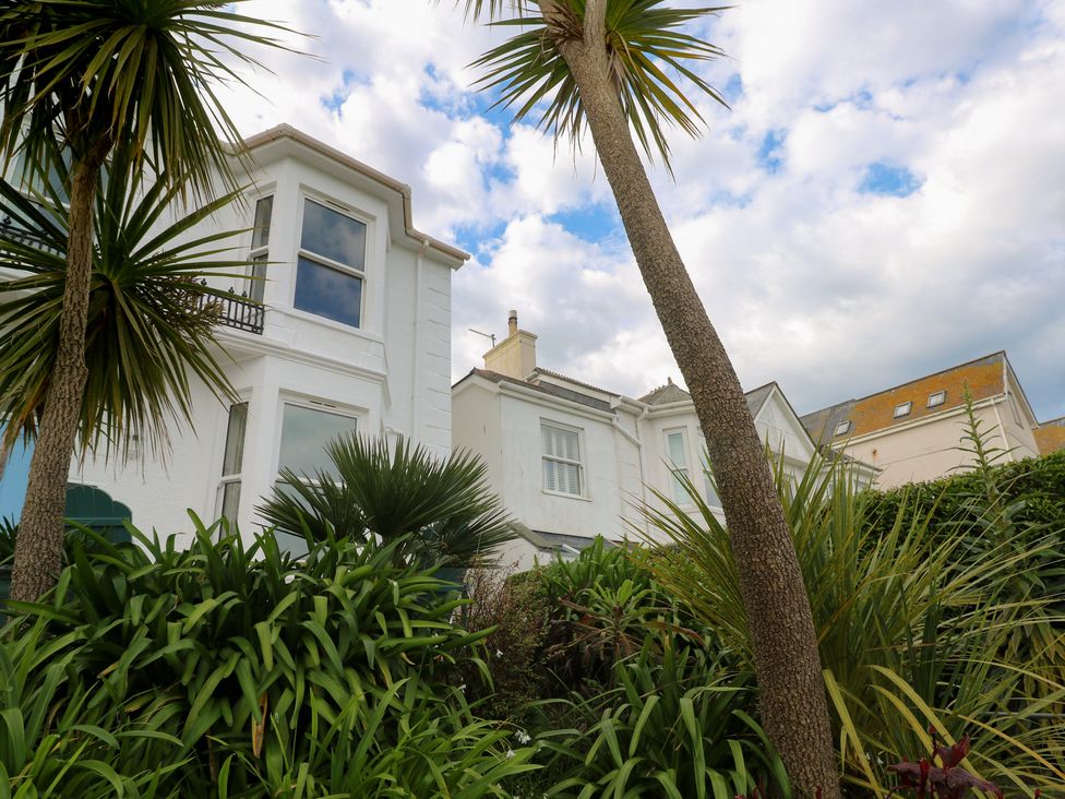 A house with palm trees and plants in the garden at Apartment 1 Llewellan in St Ives
