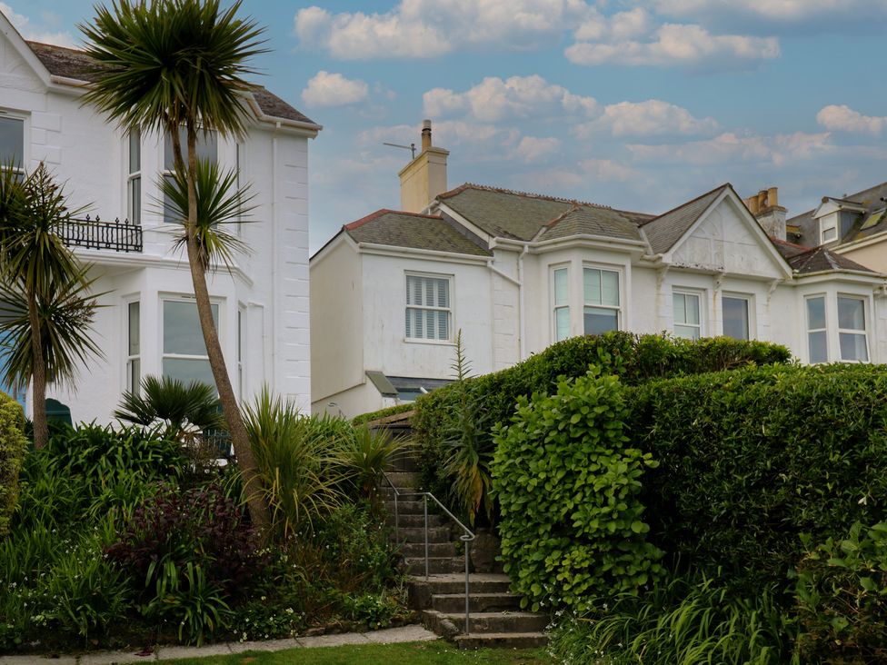 A house with a balcony and palm trees at Apartment 1 Llewellan in St Ives