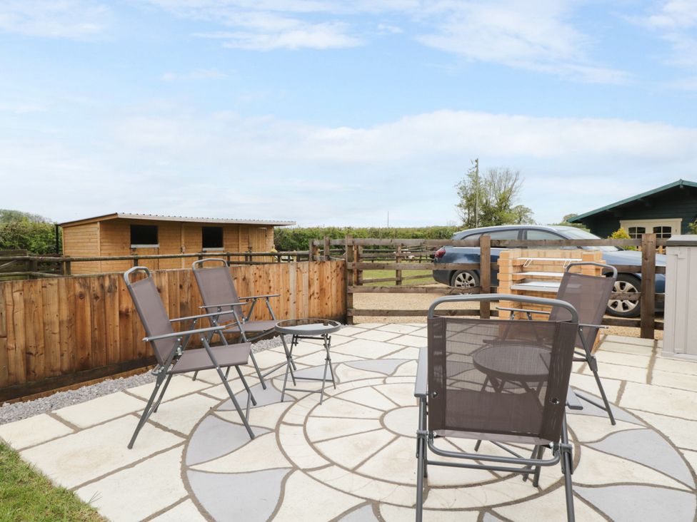 An outdoor seating area with chairs and a table at The Log Cabin in Bushton near Royal Wootton Bassett