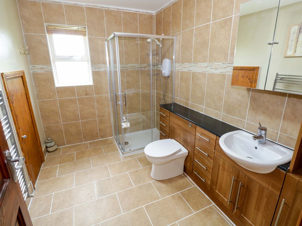 A bathroom with a shower, sink, and toilet at Ballaghboy Cottage in Boyle, County Sligo