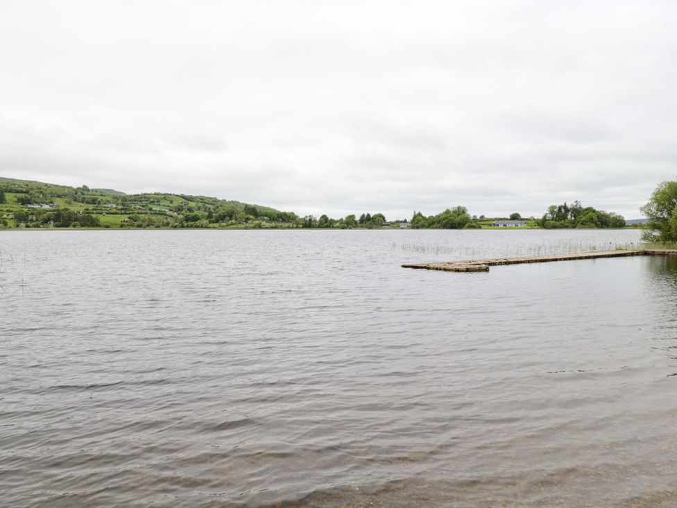 A lake with a pier and hills in the background at Ballaghboy Cottage in Boyle, County Sligo
