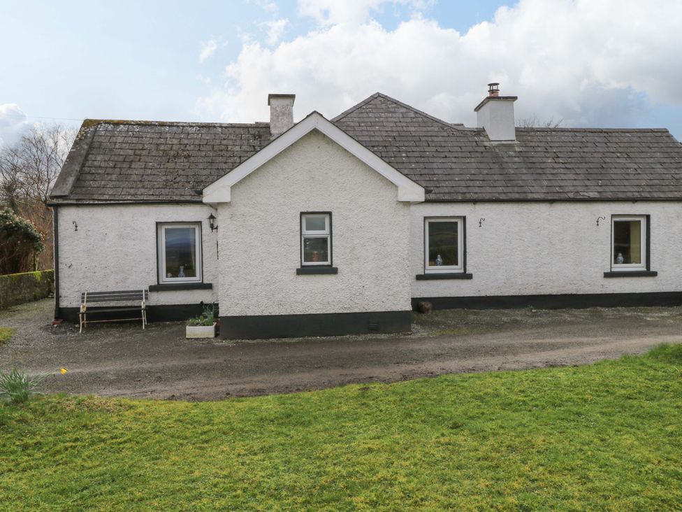 A house with windows and a bench outside at Ballaghboy Cottage in Boyle, County Sligo