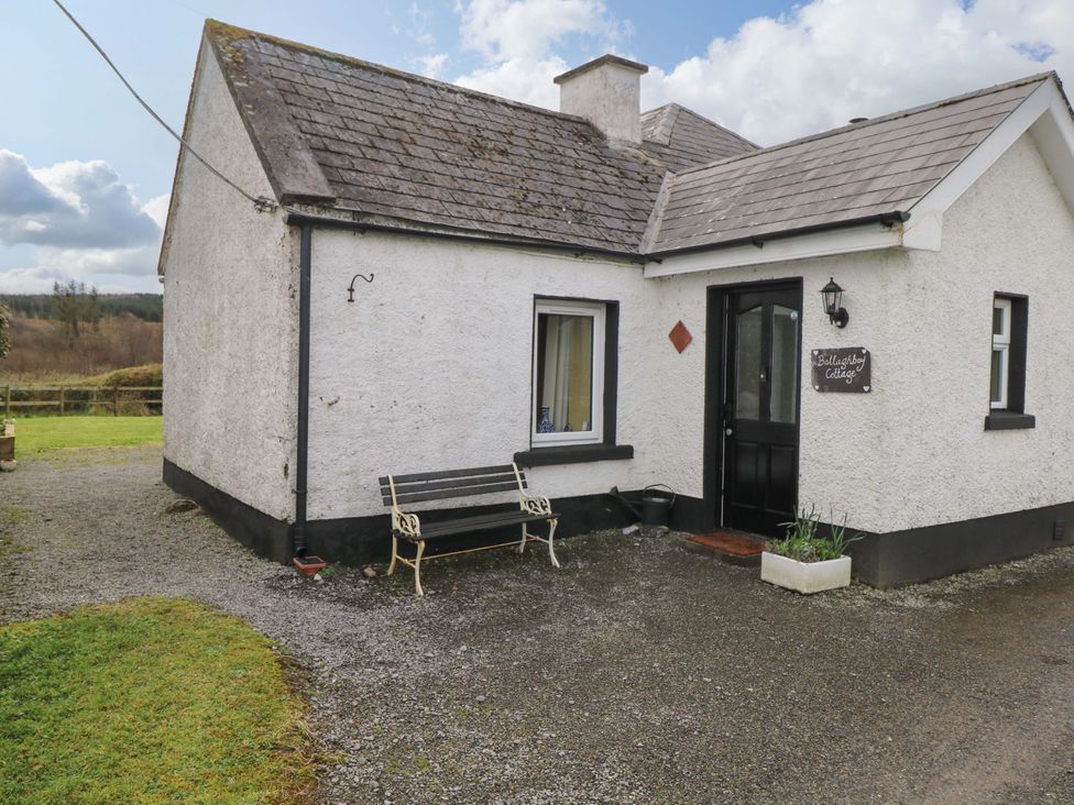 A cottage exterior with a bench and front door at Ballaghboy Cottage in Boyle, County Sligo