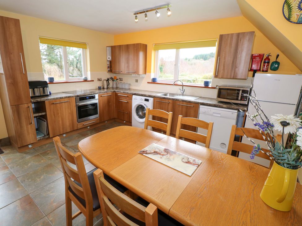 A kitchen with appliances and a dining table at Ballaghboy Cottage in Boyle, County Sligo