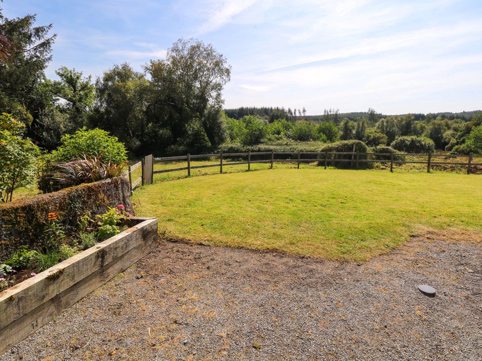 A garden with a flower bed and a wooden fence at Ballaghboy Cottage in Boyle, County Sligo