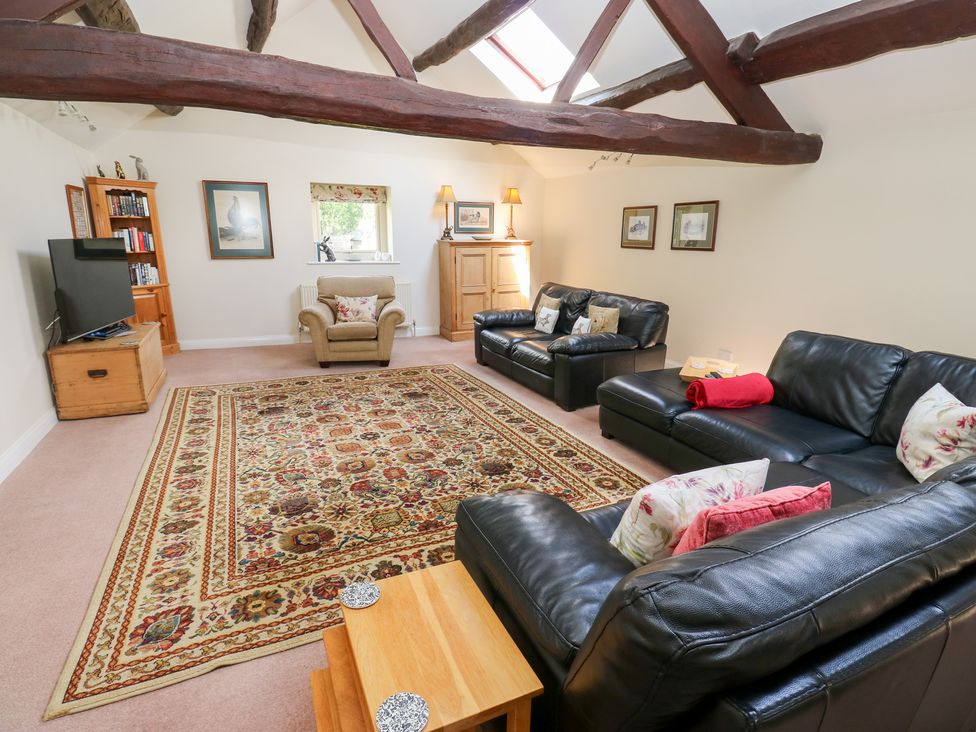 A living room with sofas and a television at Bullace Barn in Millhouse Green
