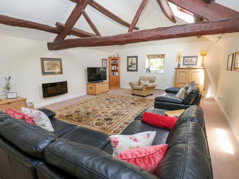 A living room with a sofa and television at Bullace Barn in Millhouse Green