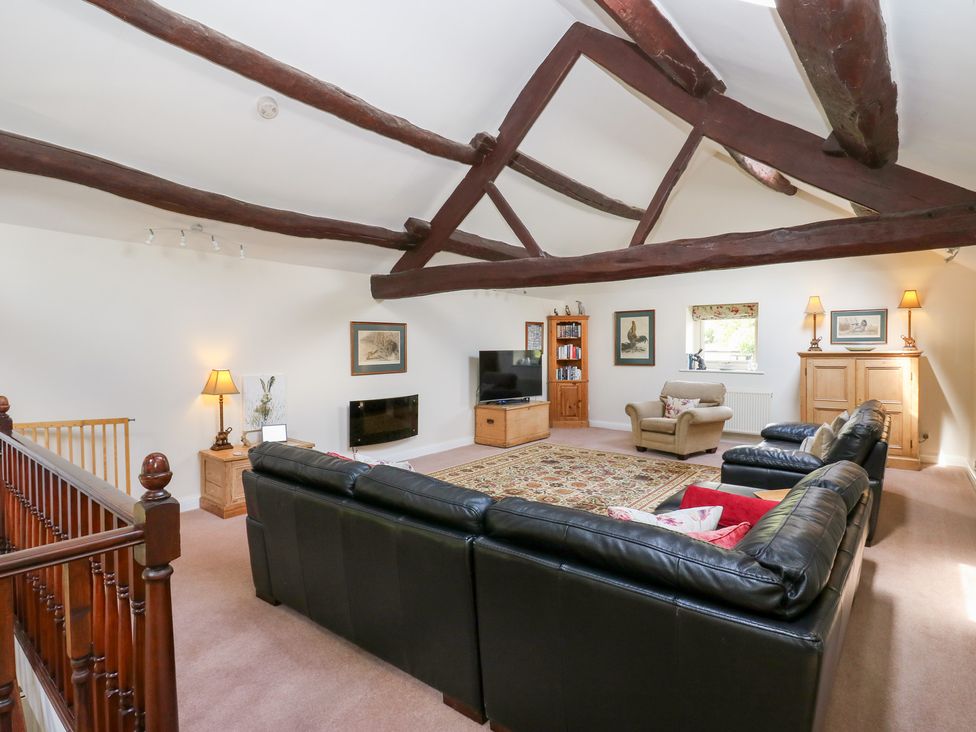A living room with a sofa and television at Bullace Barn in Millhouse Green