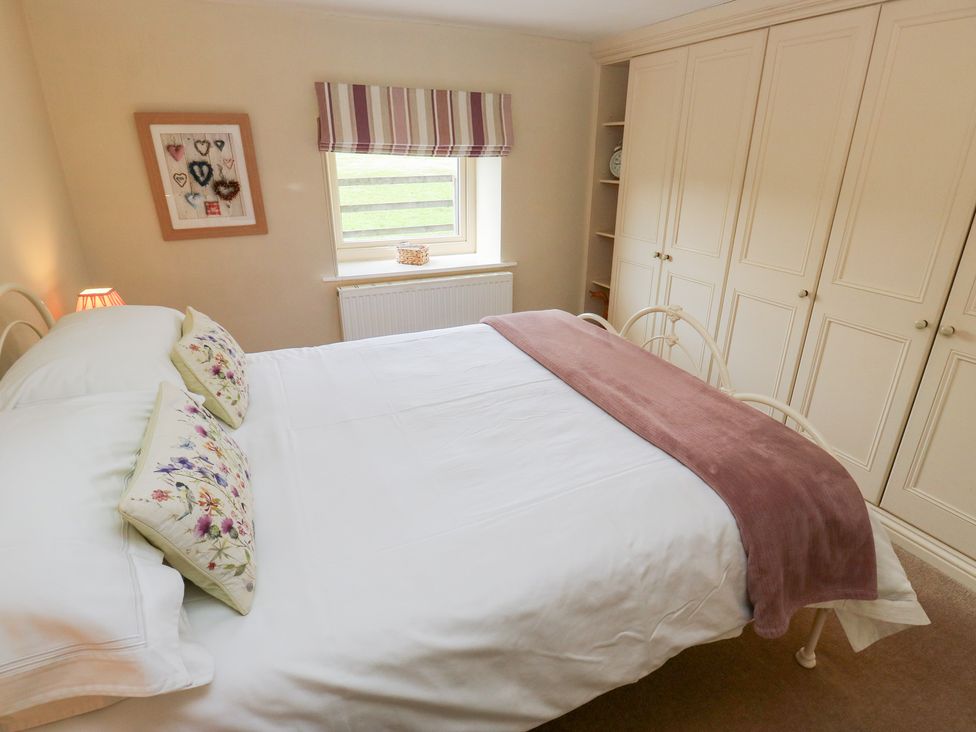 A bedroom with a bed and wardrobe at Bullace Barn Millhouse Green
