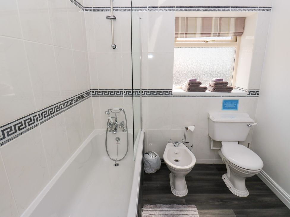 A bathroom with a bathtub, toilet, and bidet at Bullace Barn in Millhouse Green