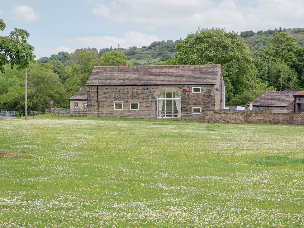 A house surrounded by grass and trees at Bullace Barn in Millhouse Green