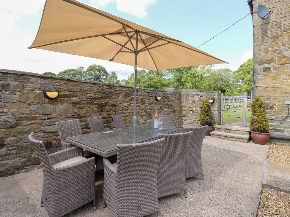 An outdoor dining area with table and chairs at Bullace Barn Millhouse Green