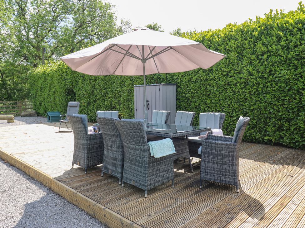An outdoor dining area with a table and chairs at Bullace Barn Millhouse Green