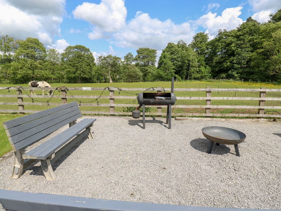 An outdoor area with a bench, barbecue grill, and fire pit at Bullace Barn Millhouse Green