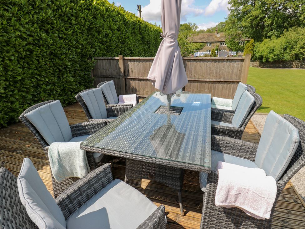 An outdoor dining area with a table and chairs at Bullace Barn in Millhouse Green