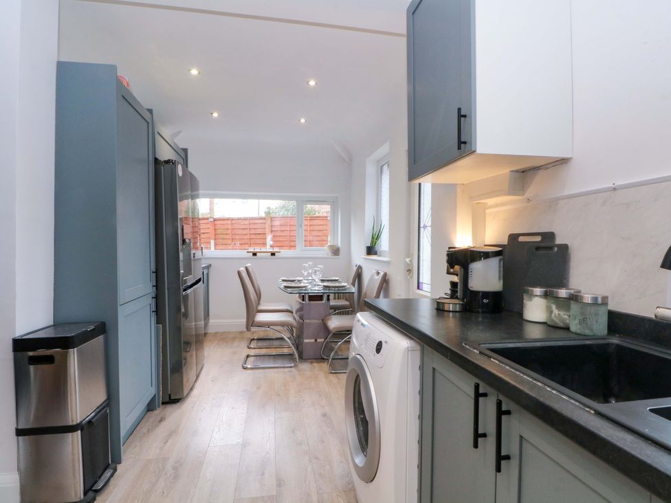 A kitchen with appliances and dining area at Thomas Lane in Liverpool