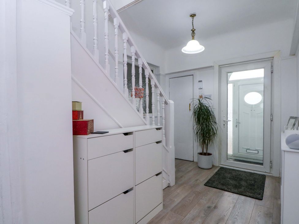 A hallway with a staircase and drawer unit at Thomas Lane in Liverpool
