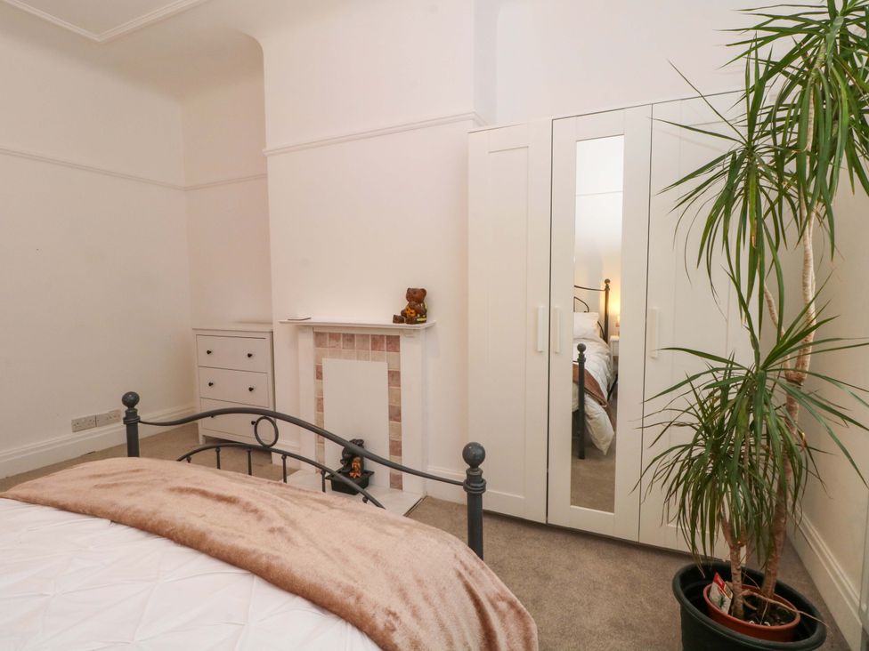 A bedroom with a bed, wardrobe, and chest of drawers at Thomas Lane in Liverpool