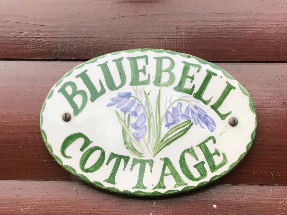 A decorative sign that reads Bluebell Cottage with flower design at Bluebell Lodge Saltburn-by-the-Sea