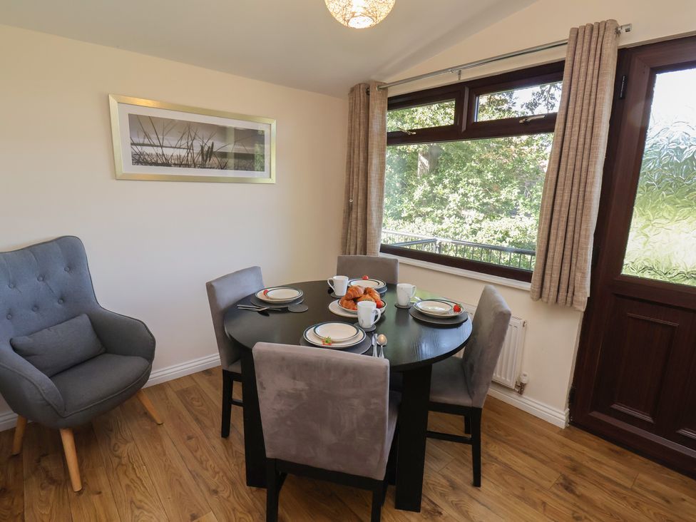 A dining room with a round table and chairs at Bluebell Lodge in Saltburn-by-the-Sea