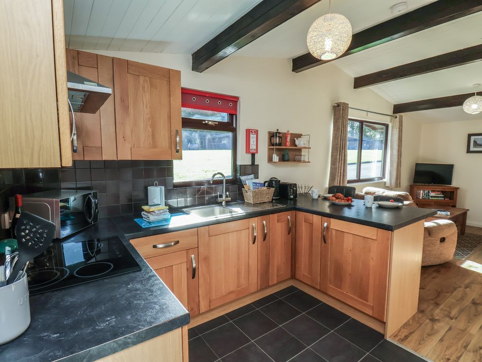 A kitchen with wooden cabinets and appliances at Bluebell Lodge in Saltburn-by-the-Sea