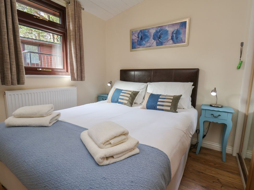 A bedroom with a bed and nightstand at Bluebell Lodge in Saltburn-by-the-Sea