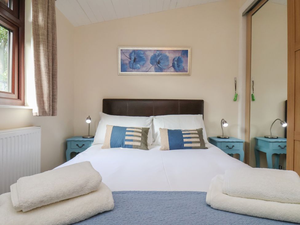 A bedroom with a bed and nightstands at Bluebell Lodge in Saltburn-by-the-Sea