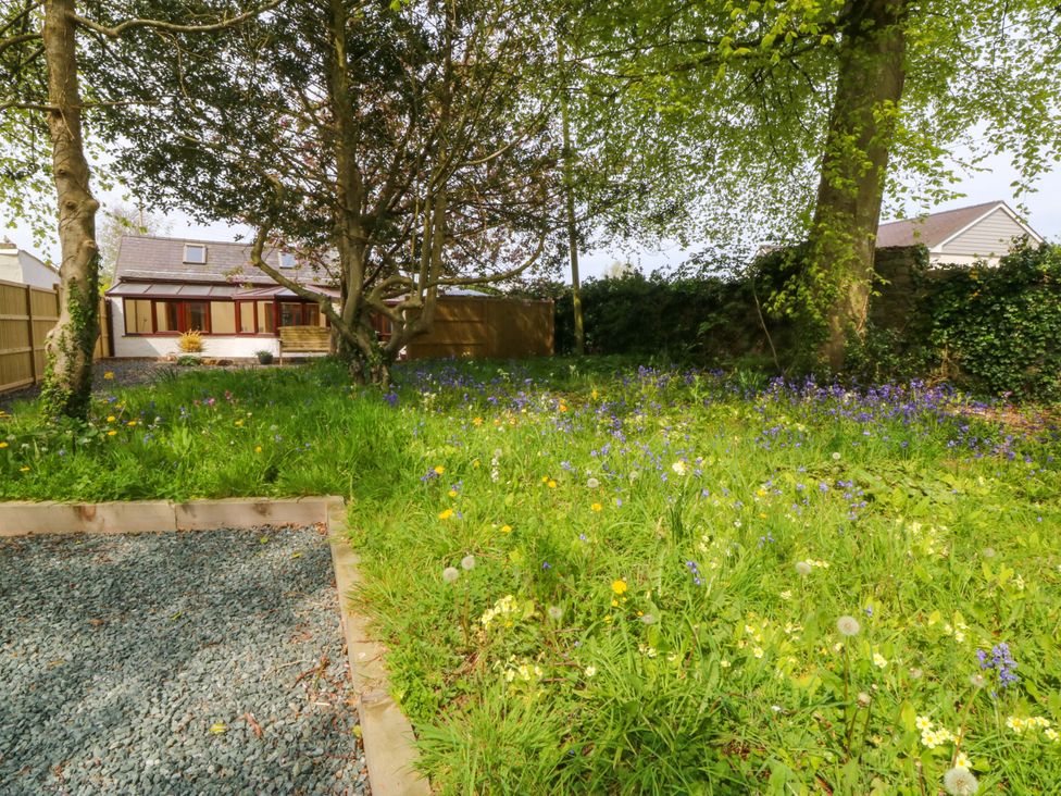 A garden with flowers and a house at Ty Taid in Llanddaniel Fab near Beaumaris