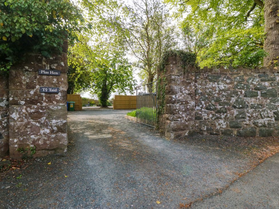 A pathway with a stone wall and a gate at Ty Taid in Llanddaniel Fab near Beaumaris